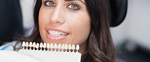 Cosmetic dentist in Agawam comparing veneer shades with patient