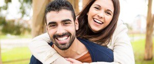 Woman on man’s back outdoors