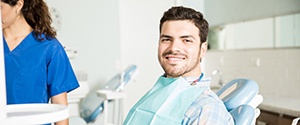 Man in plaid shirt smiling in dental chair