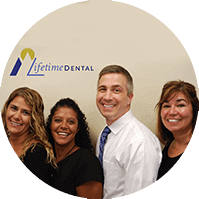 Agawam dentist and dental team next to Lifetime Dental of Agawam sign