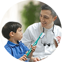 Agawam dentist with young boy holding giant toothbrush