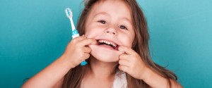 Child makes silly face with toothbrush