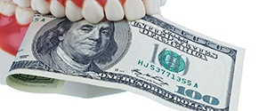 Dental model holding a $100 bill