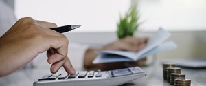 Man using calculator to determine cost of dentures in Feeding Hills