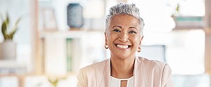 a businesswoman smiling with her new dentures