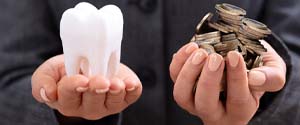 Hands holding coins and tooth