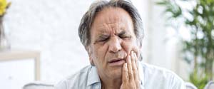 Man with a toothache holding his face