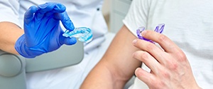 a dentist giving a patient custom mouthguards