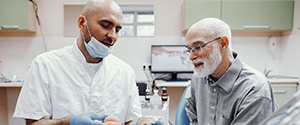 a dentist explaining implant dentures to a patient