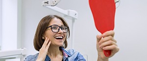 young woman admiring her new dental implants in Agawam 