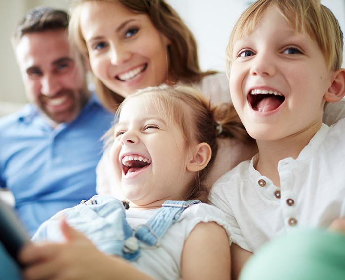 Mother father and two young children laughing