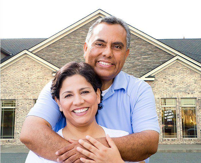 Smiling man and woman holding each other outdoors