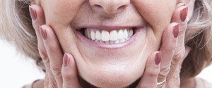 Older woman framing beautiful smile with hands
