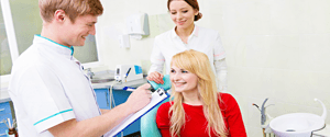 Woman in dental chair discuss insurance coverage