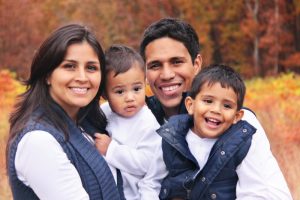 family of four smiling and hugging