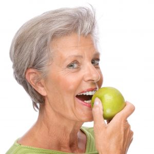 woman smiling holding an apple