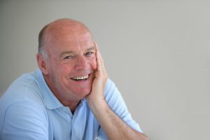 older man smiling blue shirt