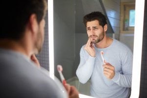 person holding their mouth because they have sensitive teeth 