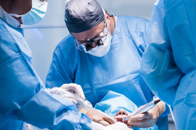 a dentist performs dental implant surgery on a patient