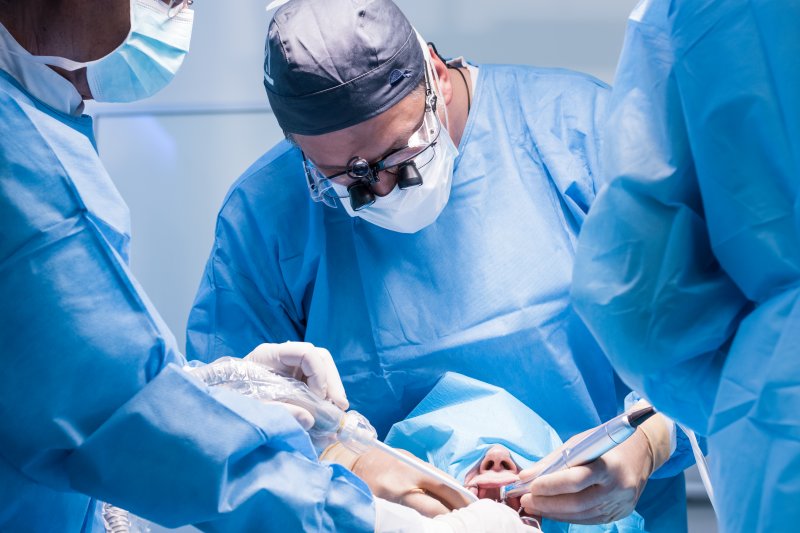 a dentist performs dental implant surgery on a patient 